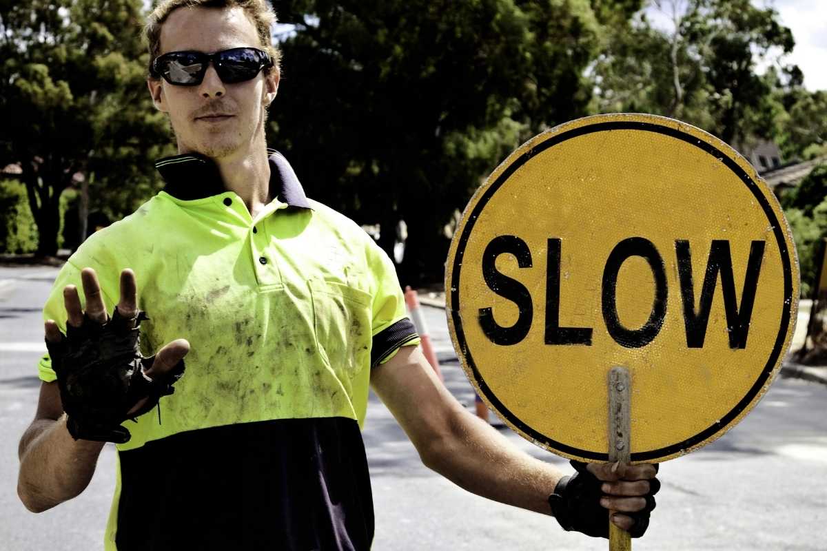 worker holding slow sign
