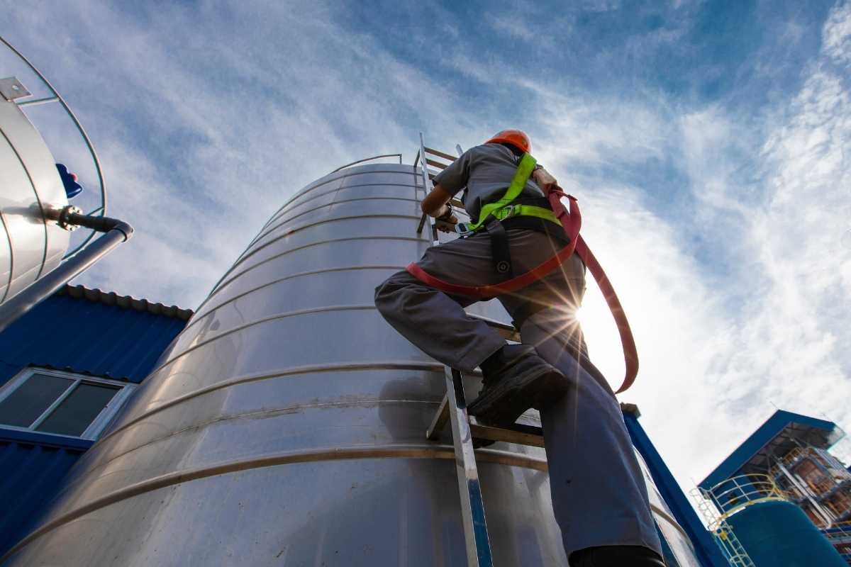 worker climbing a silo on a ladder